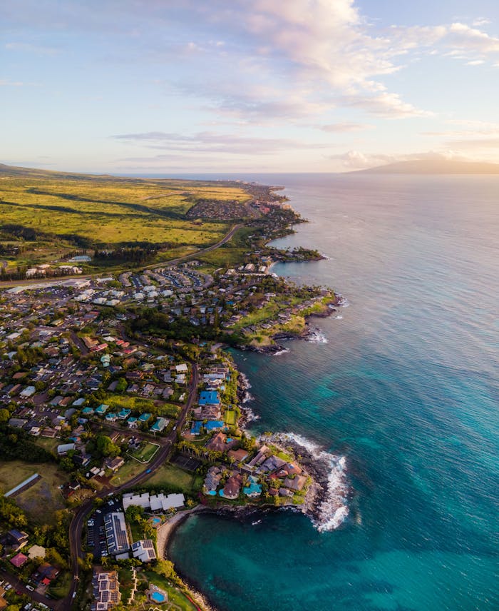 Stunning aerial shot of Lahaina, Hawaii coastline during sunset, showcasing vibrant townscape and ocean views.